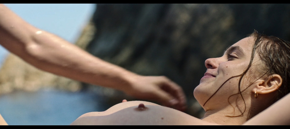 Clara Galle lays on the beach exposing nipples